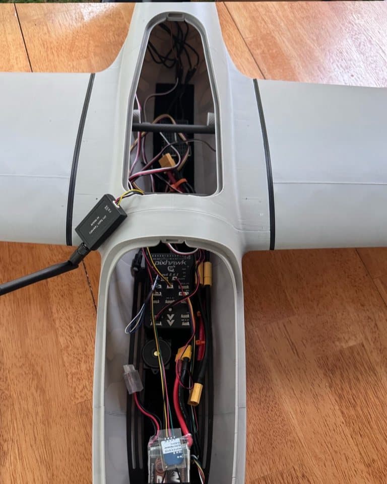 Avionics and power wiring inside a fixed-wing airframe during assembly.